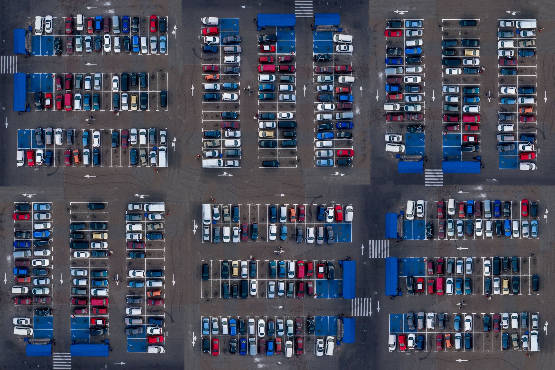 Vista superior aérea do estacionamento com muitos carros. Muitos carros estão estacionados em um estacionamento com marcas brancas. Lugares de estacionamento com padrão de veículos.